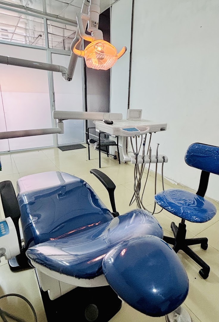 Blue dental chair beneath an illuminated examination light